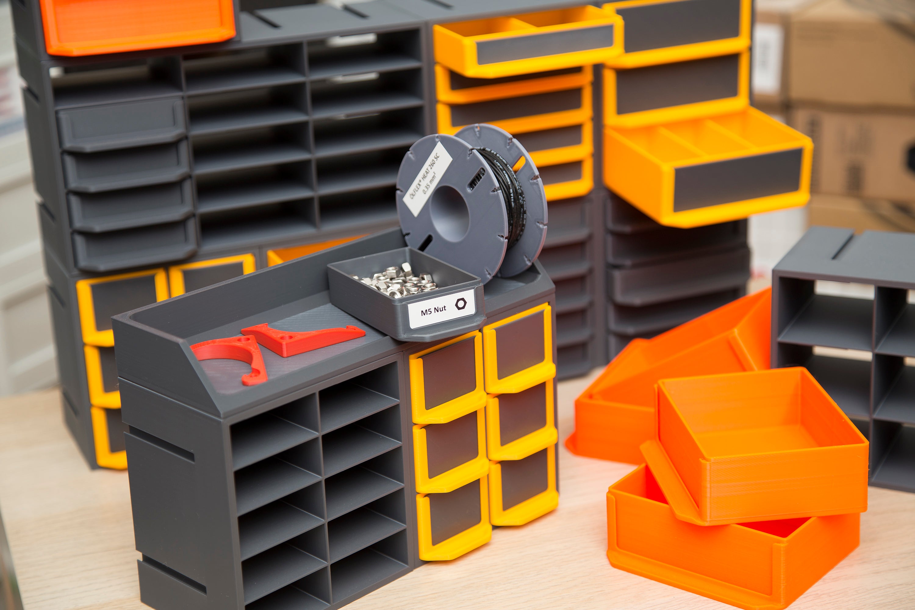 3D printed modular shelving system with drawers for small-parts storage in a workshop or hobby bench setup