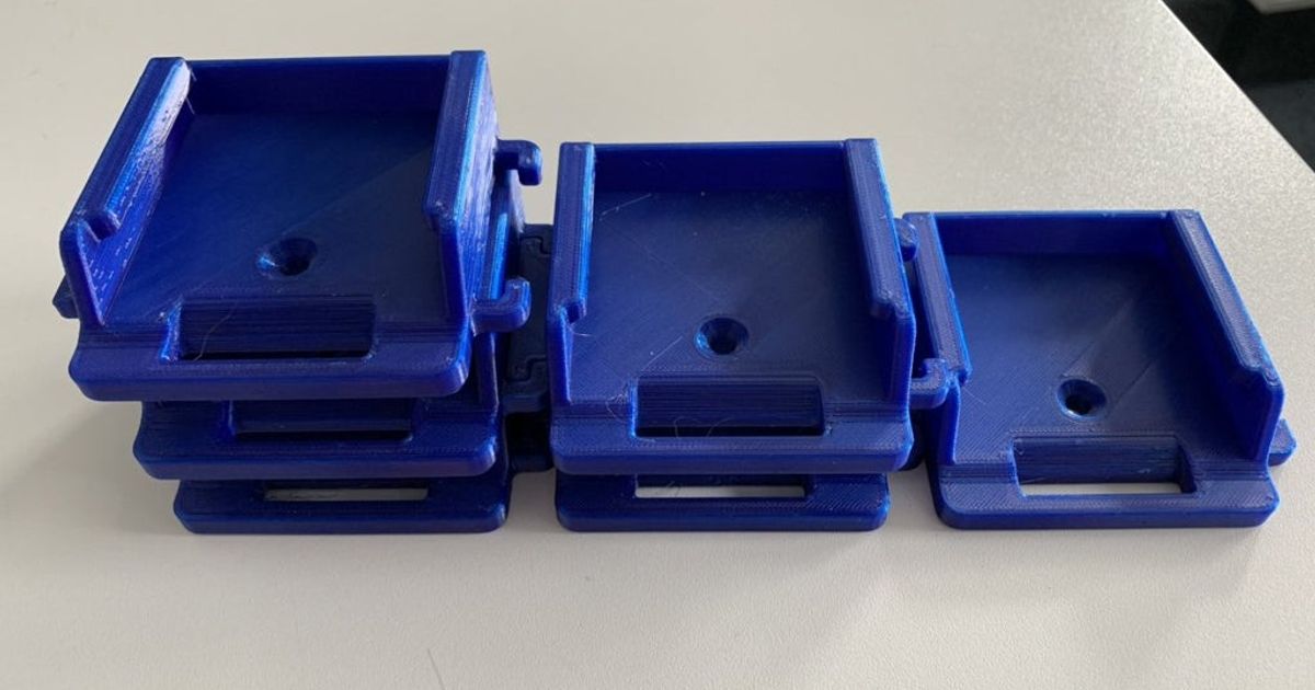 3D printed wall-mounted holder storing cordless tool batteries in a workshop