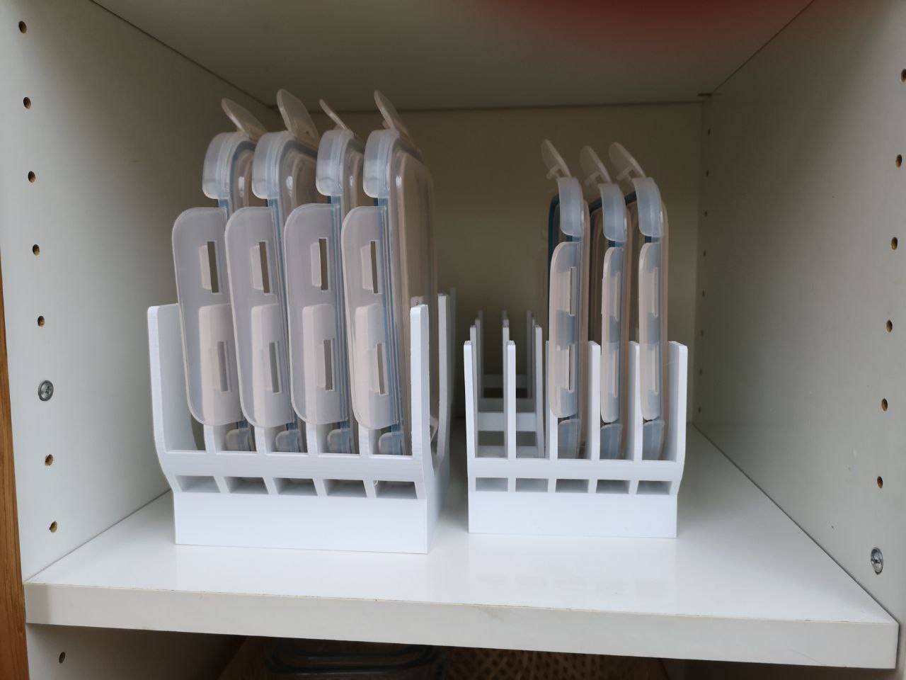 3D printed food container lid holders organizing loose kitchen lids upright inside a cabinet or drawer