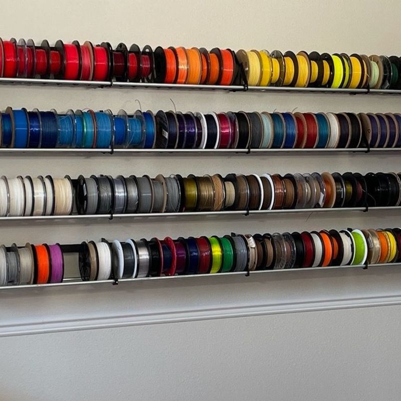 RepRack modular 3D printed filament storage system holding multiple spools on a rack