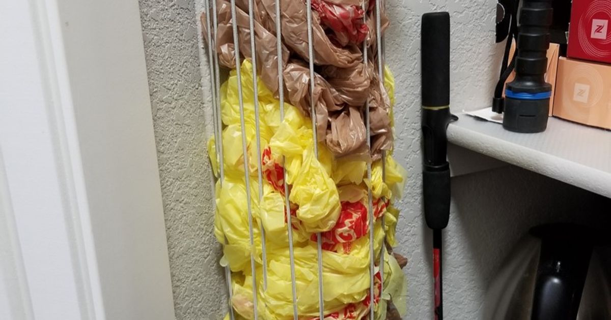 3D printed grocery bag holder mounted on a wall for storing spare shopping bags