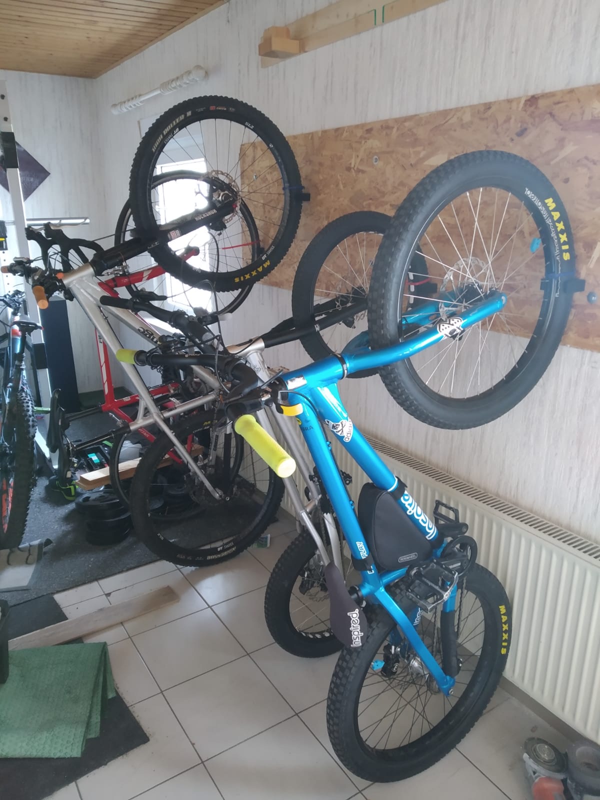 3D printed bike wall mount clip holding a bicycle by the wheel on a wall to save floor space