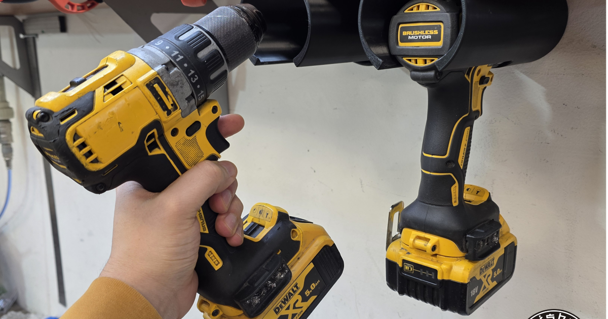 3D printed wall-mounted drill holder storing a drill vertically for cleaner workshop organization