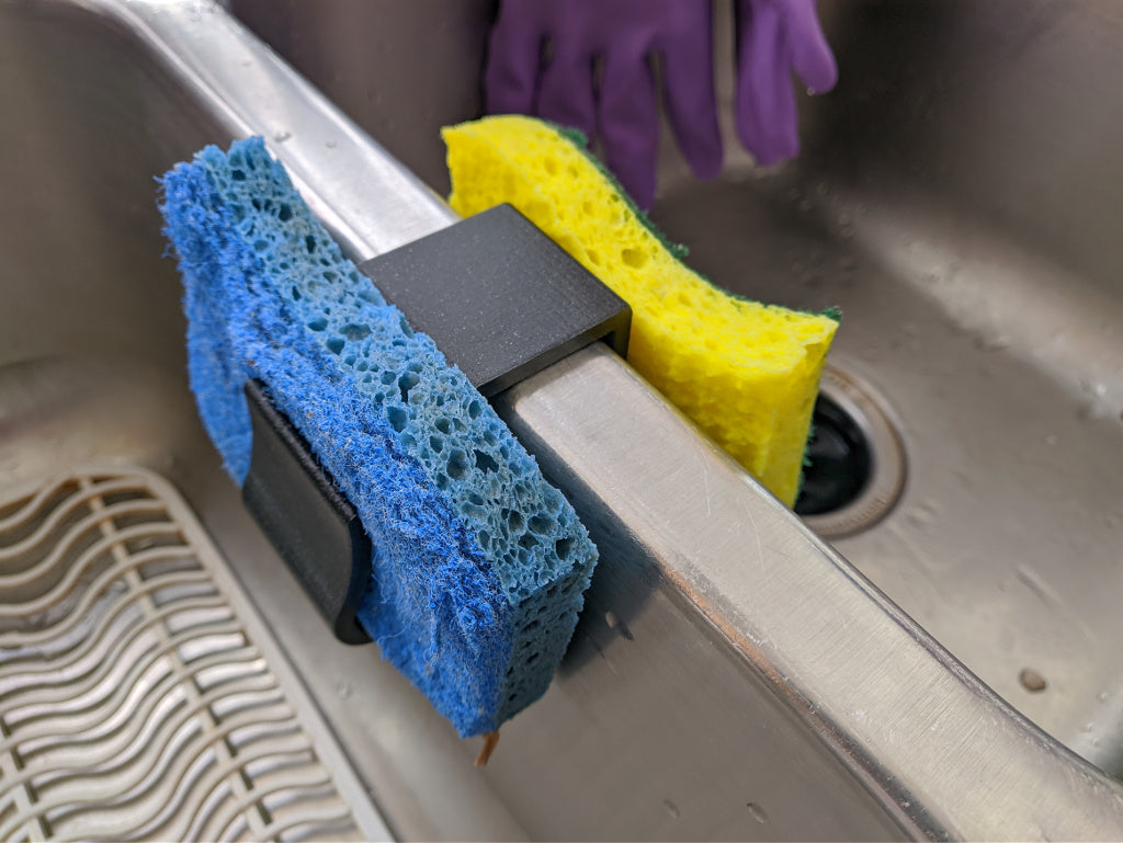 3D printed sponge holder mounted at a kitchen sink to keep a sponge draining and off the counter