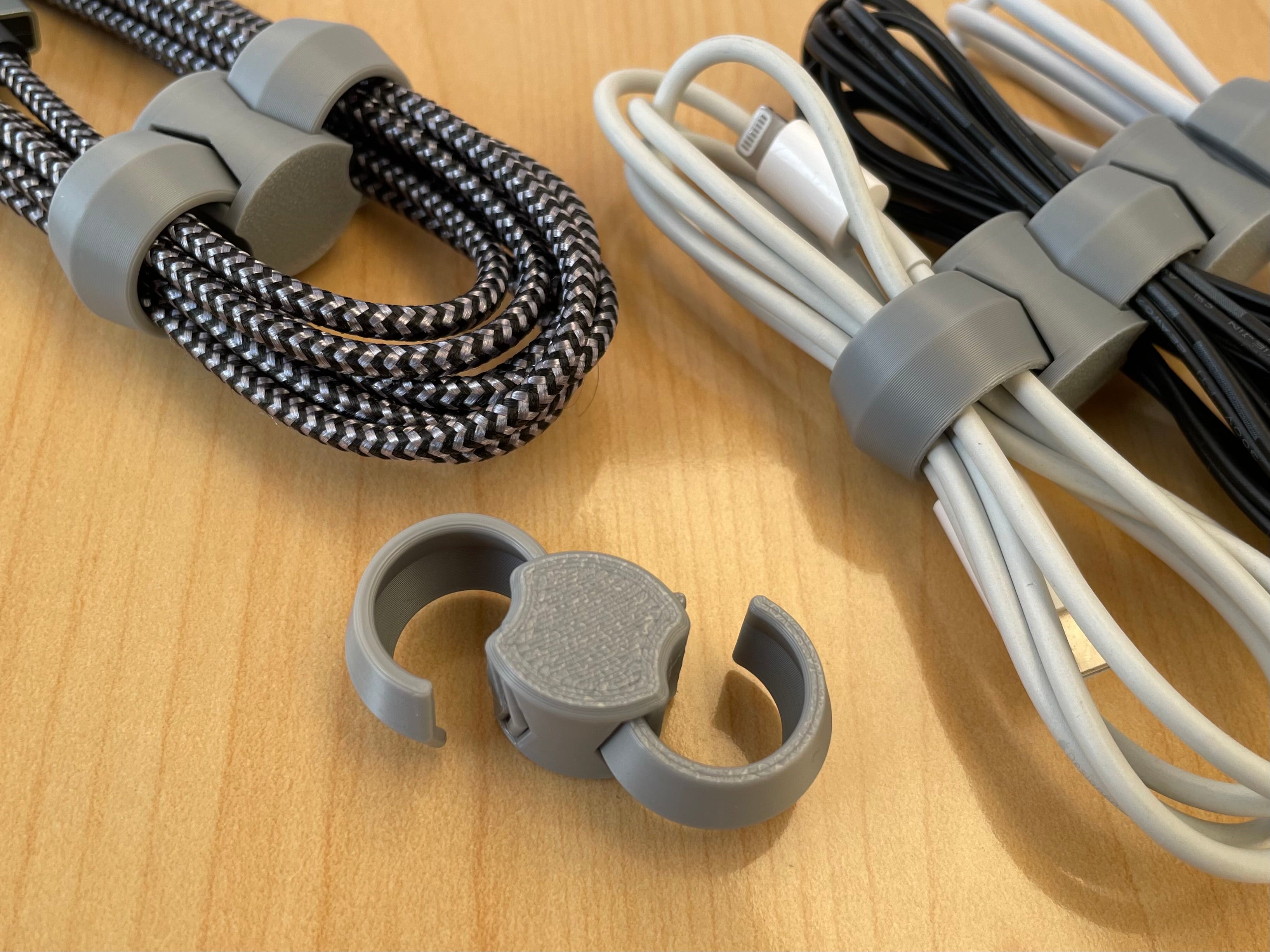 3D printed cable organizer wrapped around charging cables for tidy storage