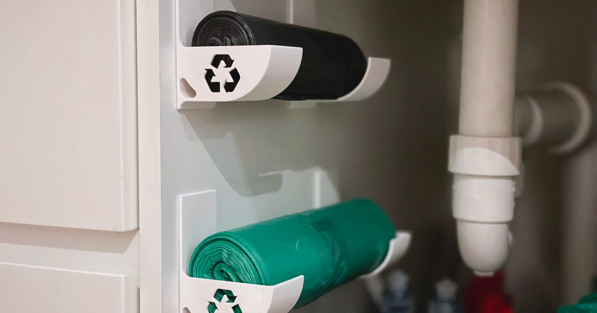 3D printed wall-mounted trash bag roll holder storing a roll of kitchen trash bags