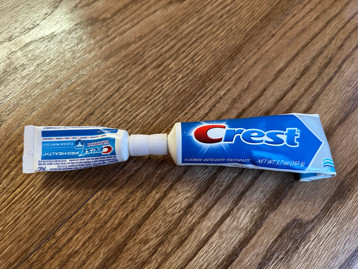 3D printed toothpaste transfer tool used to refill a smaller travel tube from a full-size toothpaste tube
