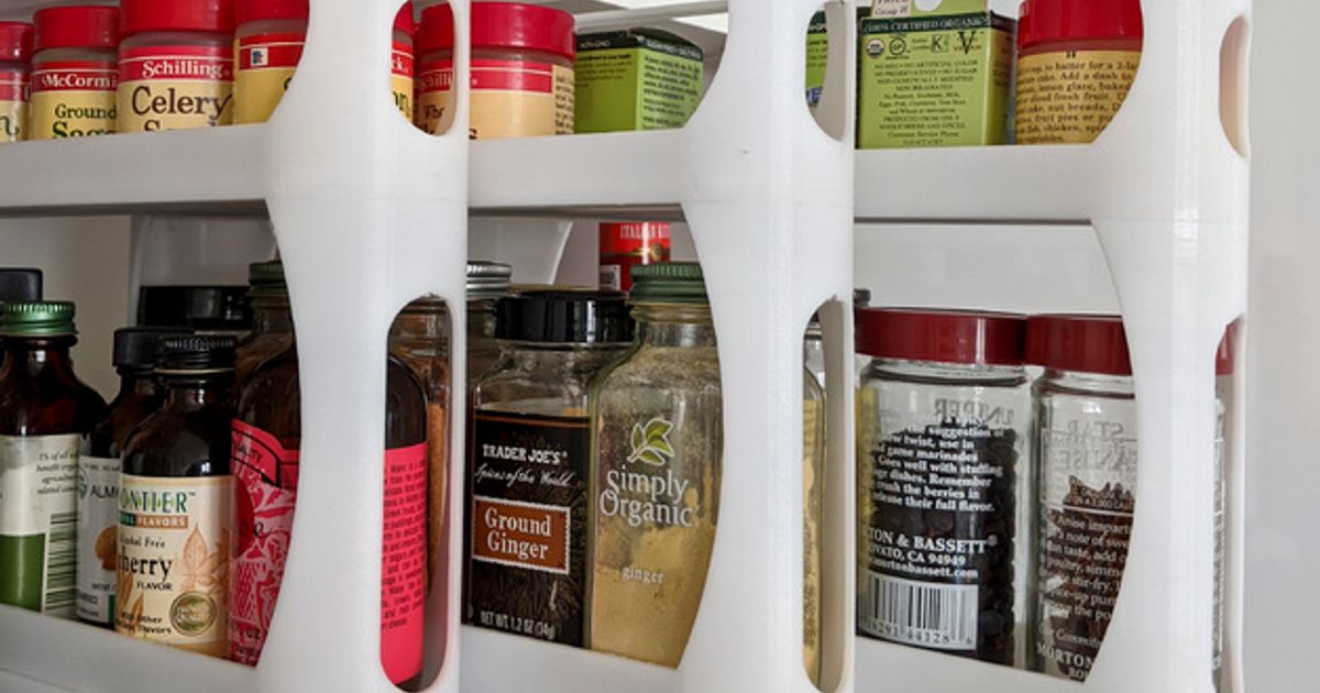 3D printed pullout spice rack holding spice jars inside a kitchen cabinet