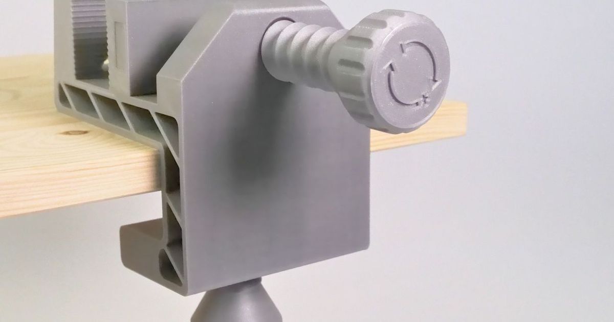 3D printed table clamp holding a small part at the edge of a workbench
