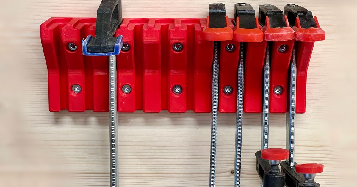 3D printed compact F-clamp holder mounted on a wall with clamps stored vertically