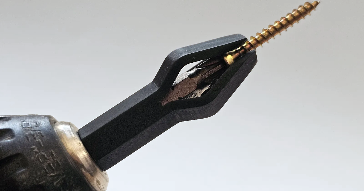 3D printed auto-releasing screw holder mounted on a driver bit for starting screws one-handed
