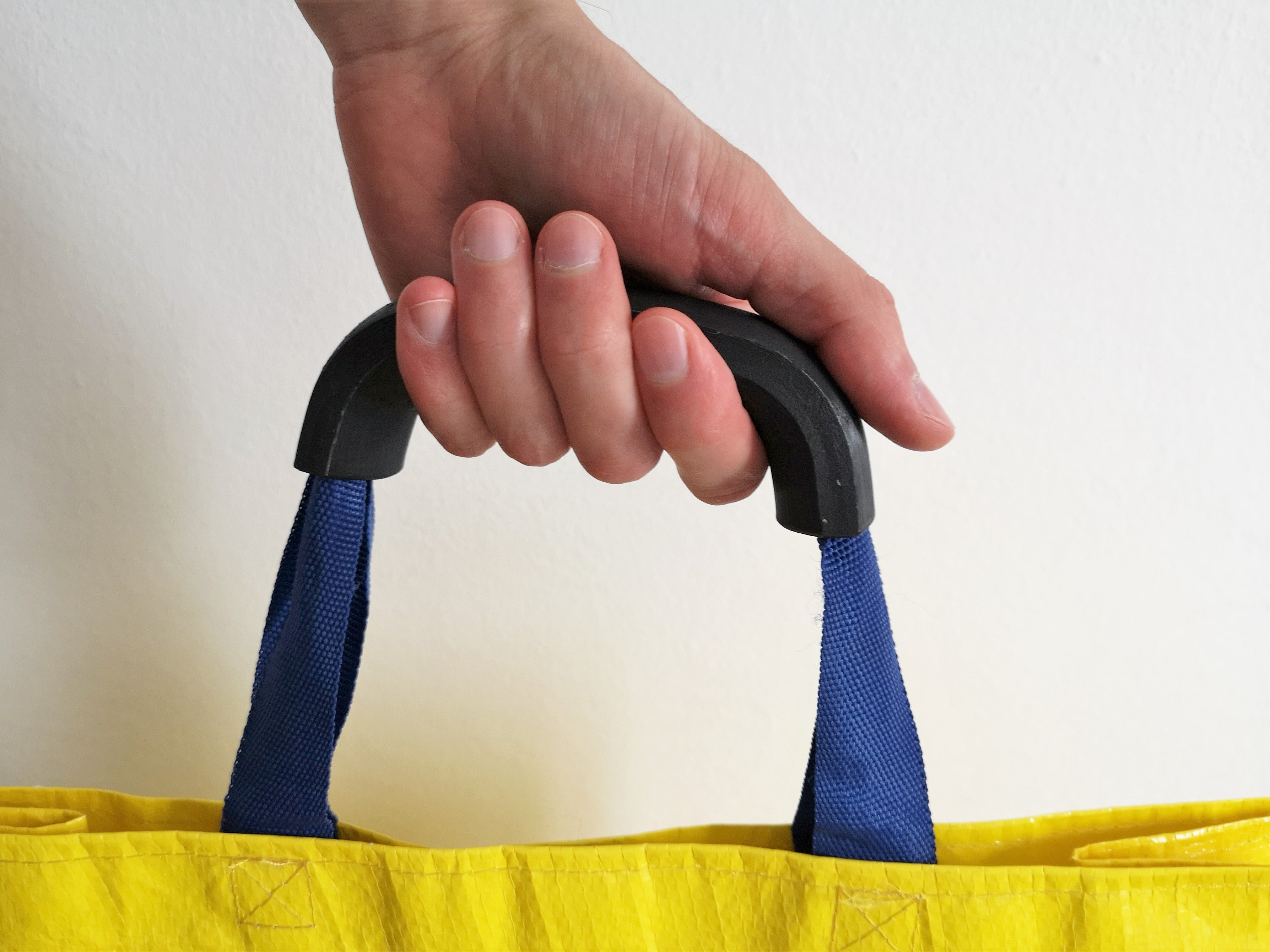 3D printed shopping bag handle carrying multiple grocery bags with a wider hand grip