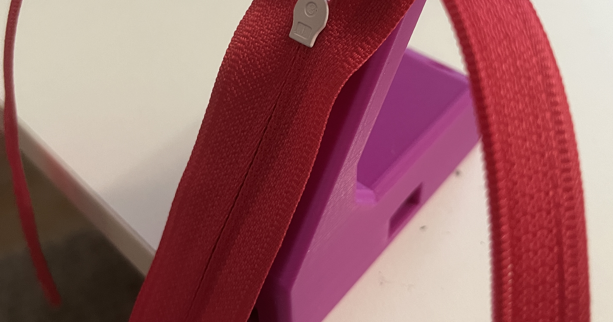 Clamp-ready zipper slider jig holding a zipper during repair